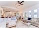 Open-concept living room boasts hardwood floors, comfortable seating, and ample natural light from the many windows at 5114 Whispering Leaf Trl, Valrico, FL 33596