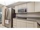 Updated kitchen with stainless steel refrigerator, built-in microwave, and modern cooktop at 5200 Brittany S Dr # 1807, St Petersburg, FL 33715