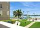 Beautiful community pool with palm trees, tiki hut, and tropical landscaping against the bay at 5200 Brittany S Dr # 1807, St Petersburg, FL 33715