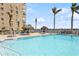Community pool area offering refreshing clear water, tiki umbrellas, and poolside seating for relaxation at 5200 Brittany S Dr # 1807, St Petersburg, FL 33715