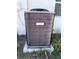 The photograph shows an HVAC system with a protective grille, set on a concrete slab, near grass and foliage at 5312 Berkley Rd, New Port Richey, FL 34652