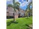 Two-story townhome with manicured lawn, lush tropical foliage, and a private entrance at 584 52Nd N Ave, St Petersburg, FL 33703