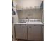 Practical laundry room equipped with a washing machine, a dryer, and overhead shelving for organized storage at 584 52Nd N Ave, St Petersburg, FL 33703