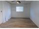Neutral bedroom with wood-look floors, decorative shelves and ceiling fan at 6516 Remus Dr, New Port Richey, FL 34653
