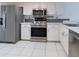 Bright kitchen featuring stainless steel appliances, white cabinets, modern backsplash and tile flooring at 6516 Remus Dr, New Port Richey, FL 34653