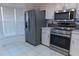 Well-lit kitchen featuring stainless steel appliances, white cabinets, and tile flooring at 6516 Remus Dr, New Port Richey, FL 34653