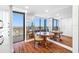 Bright dining area with wood floors, a wood table set and balcony access overlooking a stunning city view at 7600 Bayshore Dr # 1206, Treasure Island, FL 33706
