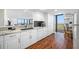Condo kitchen featuring granite counters, modern appliances, wood floors, white cabinets, and dining area access at 7600 Bayshore Dr # 1206, Treasure Island, FL 33706