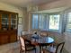 Bright dining room featuring a wooden table, shuttered windows, and china cabinet at 776 Lakewood Dr, Palm Harbor, FL 34684