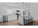 Sleek white kitchen featuring stainless steel appliances, granite countertops, and a functional breakfast bar at 8335 Fountain Ave, Tampa, FL 33615