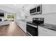 Beautiful kitchen with stainless appliances, breakfast bar, and seamless flow into the living room with fireplace at 8335 Fountain Ave, Tampa, FL 33615
