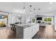 Open-concept living and dining area with hardwood floors, a fireplace, and a kitchen island, perfect for entertaining at 8335 Fountain Ave, Tampa, FL 33615