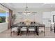 Dining room with modern chandelier, a long table with seating for six, and a sideboard at 8346 Ivy Stark Boulevard, Wesley Chapel, FL 33545
