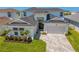 Attractive front view featuring a well-manicured lawn, a two-car garage, and a double-door entrance at 8346 Ivy Stark Boulevard, Wesley Chapel, FL 33545