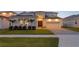 Inviting home featuring a two-car garage, manicured lawn, and elegant double door entrance at 8346 Ivy Stark Boulevard, Wesley Chapel, FL 33545