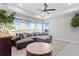 Spacious living room with a large sectional sofa, multiple windows, and ample seating for entertaining and relaxation at 8346 Ivy Stark Boulevard, Wesley Chapel, FL 33545