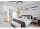 Inviting primary bedroom with ensuite bathroom featuring a tray ceiling, large window, and neutral decor at 8346 Ivy Stark Boulevard, Wesley Chapel, FL 33545