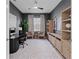 Comfortable home office with a gray walls, ample shelving, leafy rug and natural light at 8346 Ivy Stark Boulevard, Wesley Chapel, FL 33545