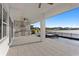 Covered patio with outdoor kitchen overlooking pool and serene lake view at 8346 Ivy Stark Boulevard, Wesley Chapel, FL 33545