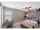 Cozy bedroom with natural light, a ceiling fan, a charming desk, and comfortable furnishings at 8704 Tarrington Pl, Tampa, FL 33635