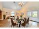 Dining area with a glass table, chandelier, and a cozy seating arrangement with bright natural lighting at 8704 Tarrington Pl, Tampa, FL 33635
