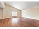 Light-filled empty room featuring hardwood flooring, bright natural lighting, and vaulted ceilings at 8704 Tarrington Pl, Tampa, FL 33635