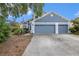 Charming home featuring a spacious three-car garage, well-maintained landscaping, and a welcoming front facade at 8704 Tarrington Pl, Tampa, FL 33635