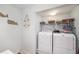 Functional laundry room with a washer, dryer, and storage shelves for convenience at 8704 Tarrington Pl, Tampa, FL 33635