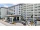 Elegant condo building showcasing intricate balcony designs, enhanced by a porte cochere and lush landscaping at 9 Forbes Pl # 205, Dunedin, FL 34698
