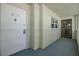 Hallway with unit 205, neutral paint, leading to a screened door at 9 Forbes Pl # 205, Dunedin, FL 34698