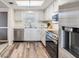 Lovely kitchen with stainless steel appliances, white cabinets, and laminate flooring at 9 Forbes Pl # 205, Dunedin, FL 34698