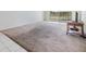 Neutral carpet in the living room with a small peek of a balcony at 9 Forbes Pl # 205, Dunedin, FL 34698