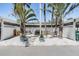 Relaxing outdoor seating area with palm trees, a grill, and white gravel at 9 Forbes Pl # 205, Dunedin, FL 34698