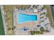 Aerial view of a resort-style pool area with ample lounge seating, surrounded by lush landscaping and serene waterways at 9 Forbes Pl # 205, Dunedin, FL 34698