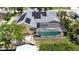Aerial view of home featuring solar panels, pool enclosure, and waterfront access with a boat dock at 907 Golf Island Dr, Apollo Beach, FL 33572
