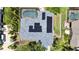 Aerial view of home featuring solar panels, pool enclosure, lush landscaping, and backyard deck at 907 Golf Island Dr, Apollo Beach, FL 33572