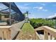 Lush backyard path leads to waterfront with pool, complemented by a tropical landscape at 907 Golf Island Dr, Apollo Beach, FL 33572