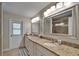 Spacious bathroom with double sinks, granite countertops, and a separate door to the exterior at 907 Golf Island Dr, Apollo Beach, FL 33572