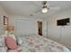 Bright bedroom featuring a ceiling fan, television, and a closet with bi-fold doors at 907 Golf Island Dr, Apollo Beach, FL 33572