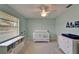 Bright Bedroom with a white crib, window bench, and soothing light blue walls, ideal for a tranquil baby space at 907 Golf Island Dr, Apollo Beach, FL 33572