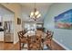 Formal dining room with vaulted ceilings, elegant chandelier, and seating for eight at 907 Golf Island Dr, Apollo Beach, FL 33572