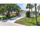 A well-maintained home featuring a lush lawn, a spacious driveway, and two Adirondack chairs at 907 Golf Island Dr, Apollo Beach, FL 33572