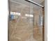 Shower with a glass door and multi-setting shower head, as well as a marble look at 907 Golf Island Dr, Apollo Beach, FL 33572