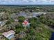 Idyllic aerial view of a serene home nestled near a scenic lake and surrounded by lush greenery at 9520 Indale Dr, New Port Richey, FL 34654
