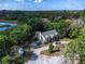 Stunning aerial view of a home nestled amidst trees, with a circular driveway and access to a nearby waterway at 9520 Indale Dr, New Port Richey, FL 34654