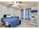 Cozy bedroom featuring a ceiling fan, tiled floors, and large windows with floral curtains at 9520 Indale Dr, New Port Richey, FL 34654