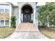 Elegant front entrance with double doors, brick steps, and decorative columns at 9520 Indale Dr, New Port Richey, FL 34654