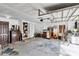 Cluttered garage with various items, cabinets, and a door to the outside at 9520 Indale Dr, New Port Richey, FL 34654