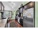 Charming kitchen with stainless steel refrigerator, granite countertops, hardwood floors and a decorative floral wallpaper at 9520 Indale Dr, New Port Richey, FL 34654