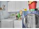 Well-equipped laundry room with a washer, dryer, sink, and ample cabinet space at 9520 Indale Dr, New Port Richey, FL 34654